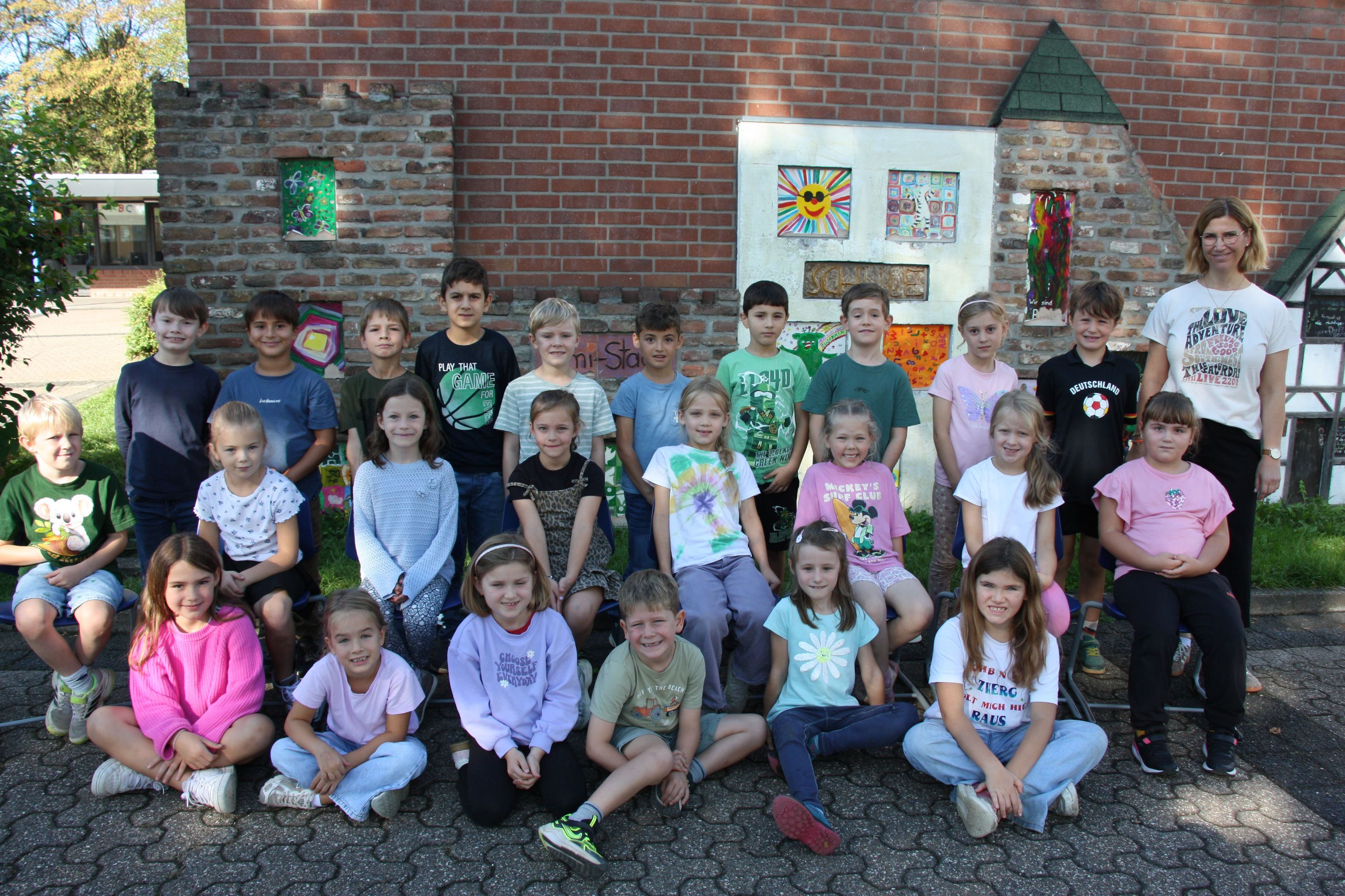Gruppenfoto von Kindern und Betreuer vor einem Kindergartengebäude.