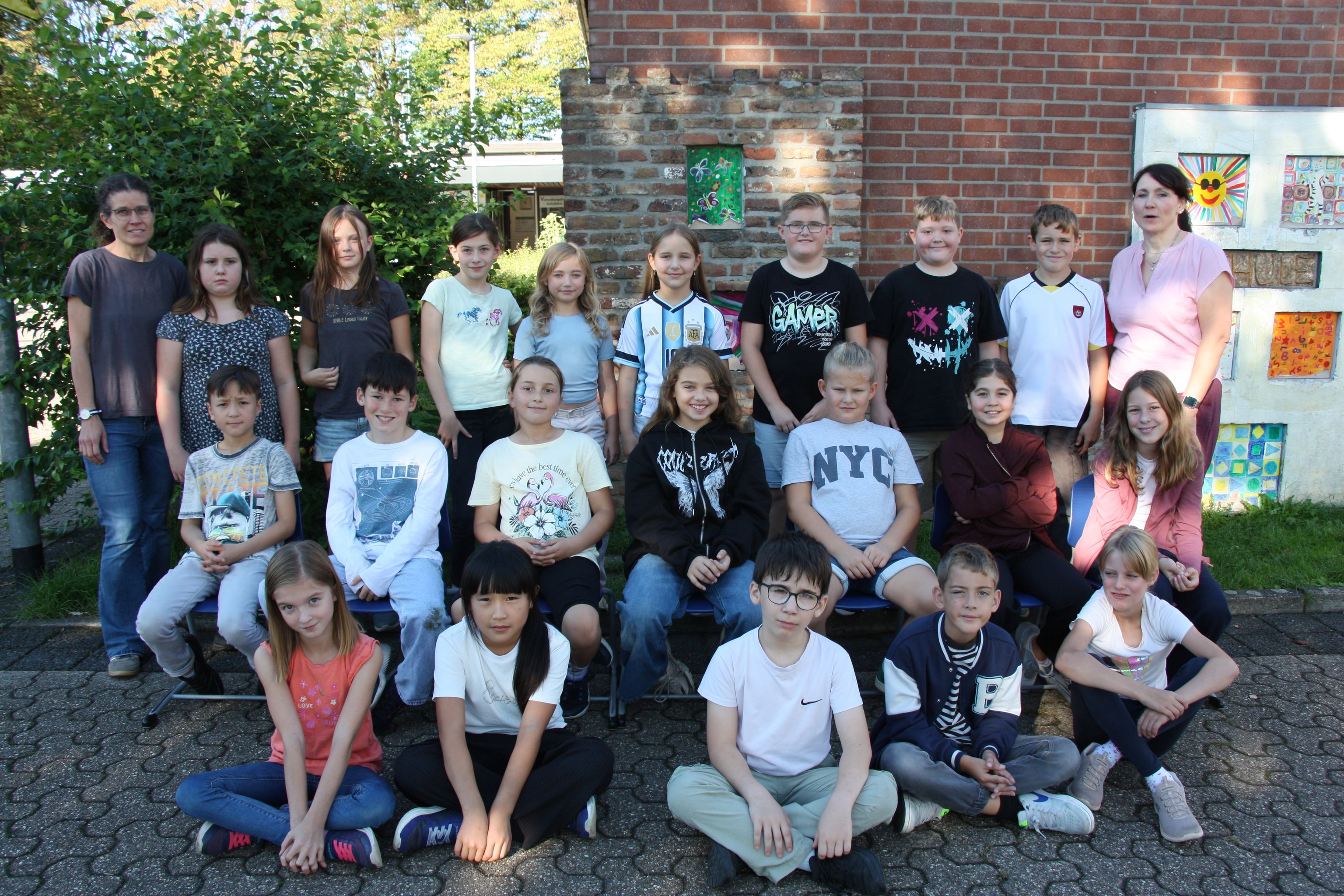 Gruppenfoto: Kinder und Betreuer vor einem Haus im Freien.