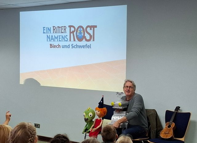 Vortragender vor Publikum mit Präsentation „Ein Ritter namens Rost – Blech und Schwefel“.